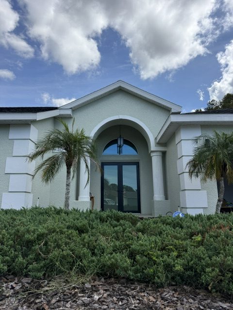 Arched entry and impact windows on a stucco home