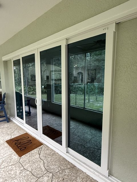 Large impact sliding glass doors with a view of the screened porch