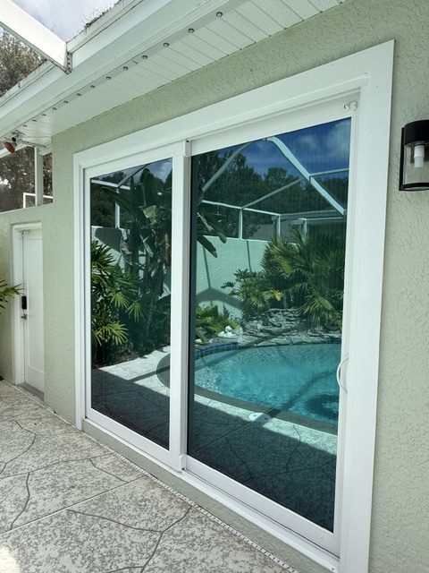 Impact sliding glass doors opening to a pool deck