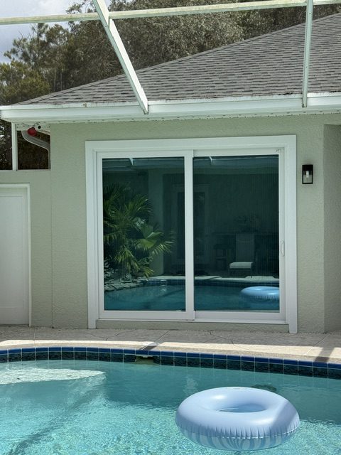 Entry doors: impact sliding glass doors facing a pool