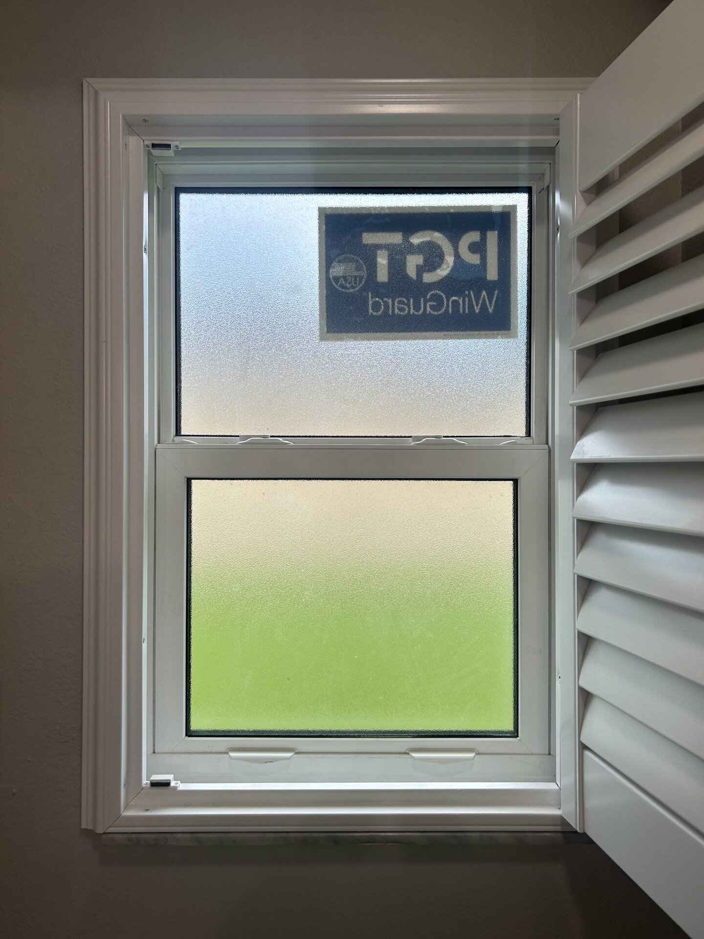 Double hung impact window with privacy glass on the lower sash