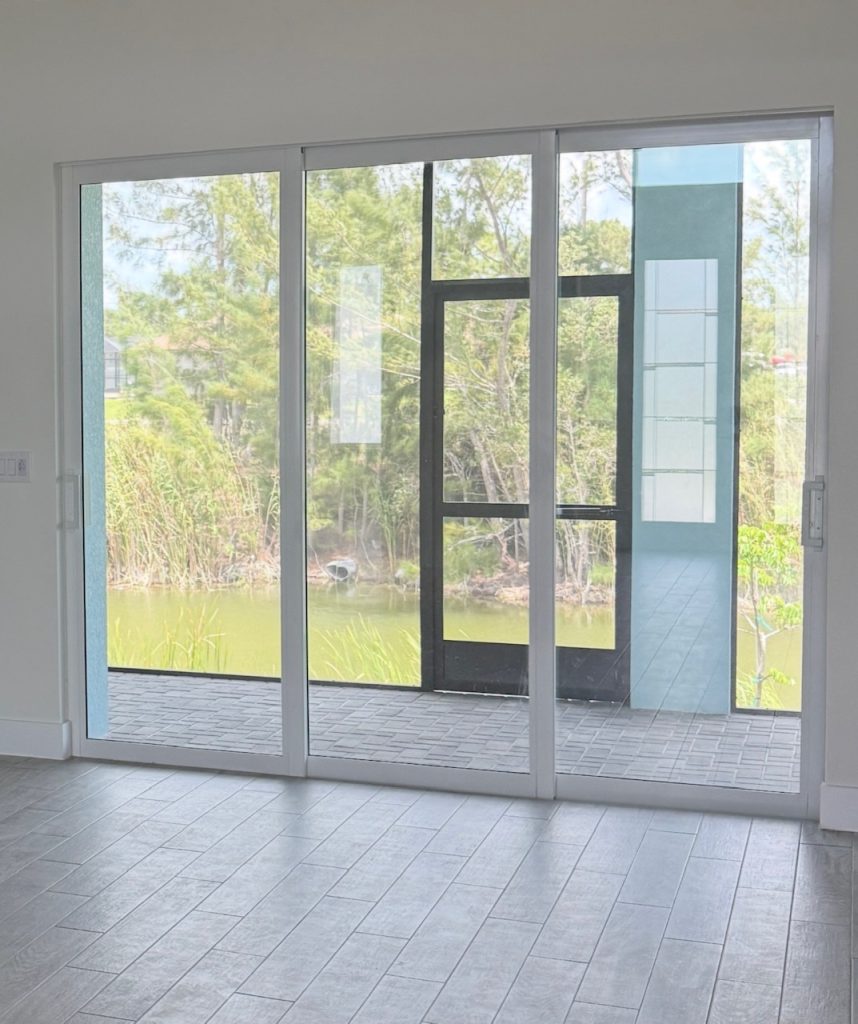 Impact windows in Belleair: impact sliding glass doors opening onto a screened lanai overlooking a pond
