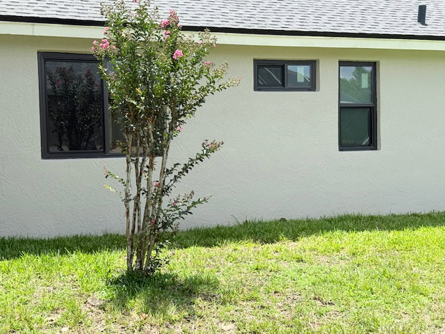 Black-frame impact windows on a stucco home, Storm Pro window replacement in Pinellas County