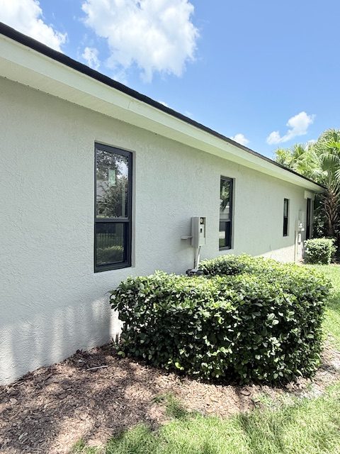 Impact windows along the side of a stucco home