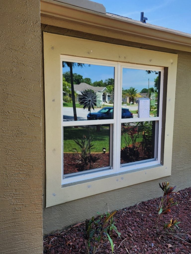 Window styles: grid impact window framed in stucco
