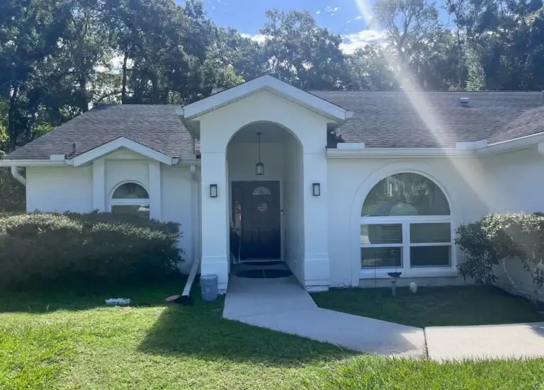 Sunlit home exterior showcasing new impact windows built to top hurricane wind ratings for windows