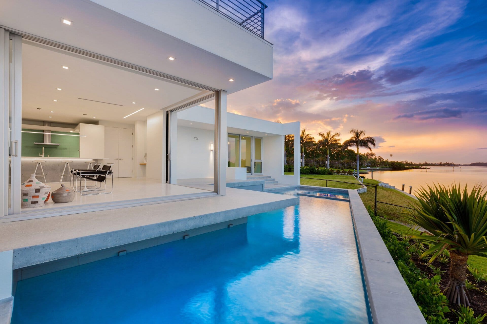 Impact window and door articles and storm guides: waterfront Florida home with large impact sliding glass doors at sunset