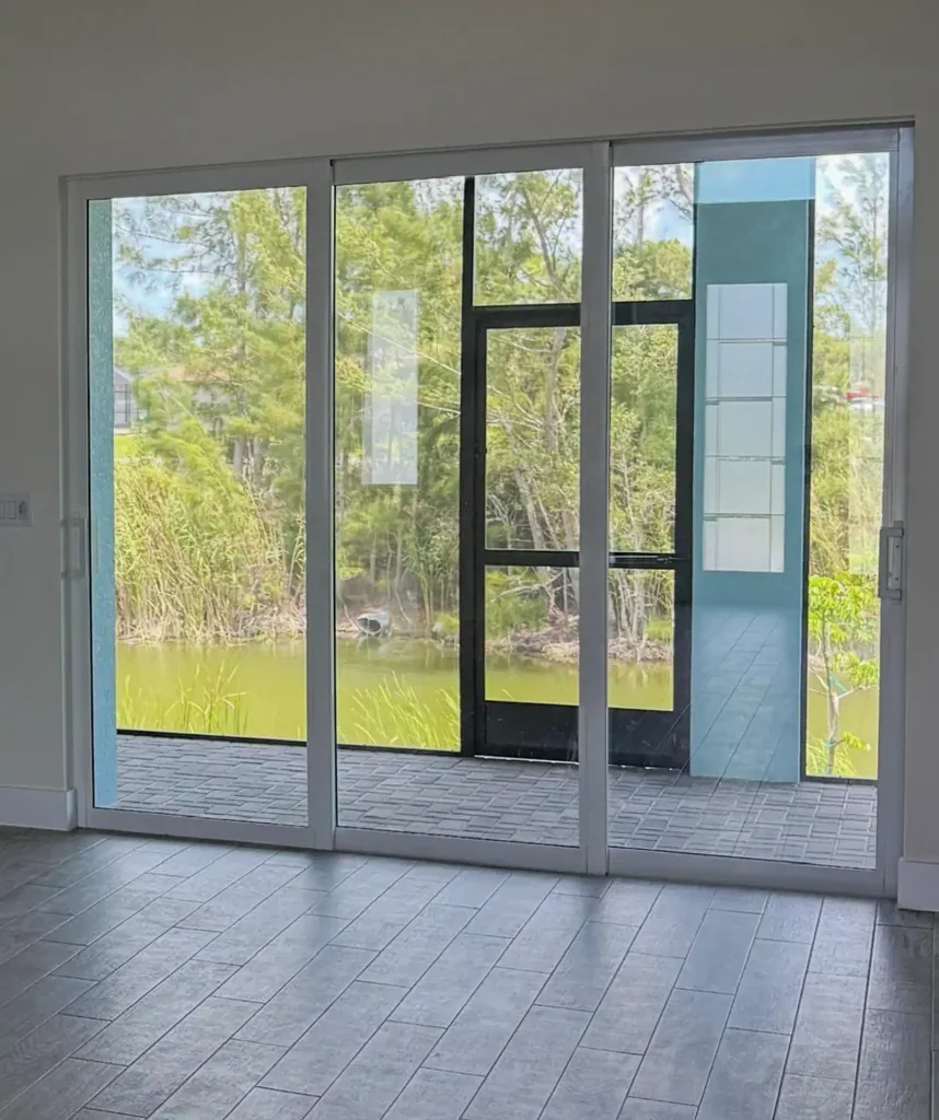 Multi-panel impact sliding glass door in a tiled living room, one of the wider sliding glass door sizes