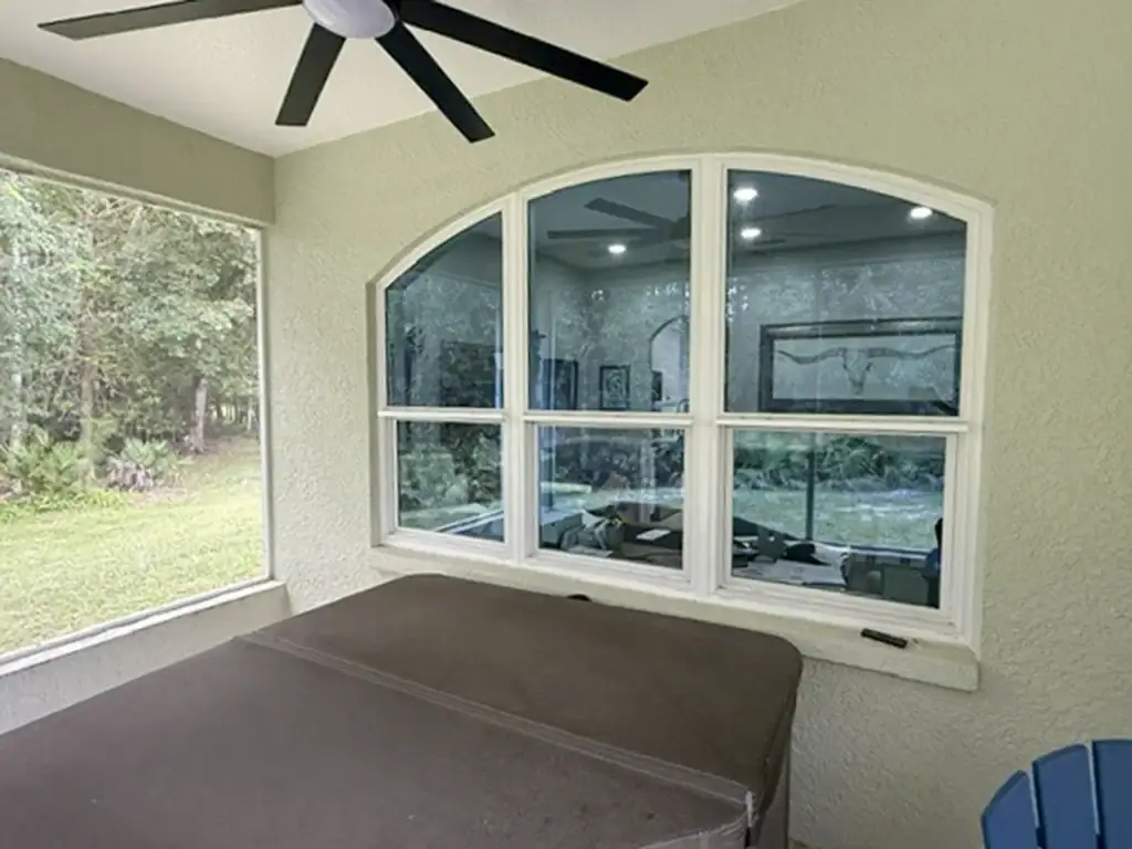 Three white-framed windows with an arched top beneath a covered patio