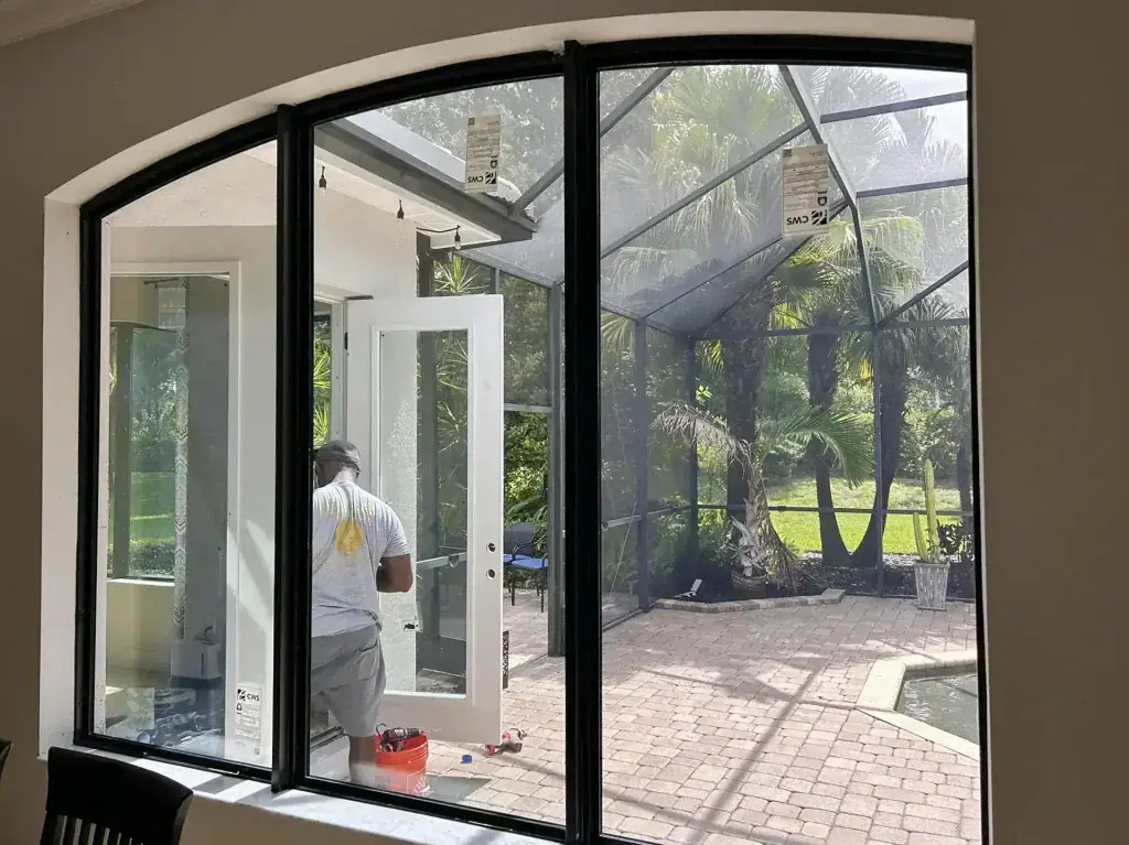Black-framed arched window group with an open casement