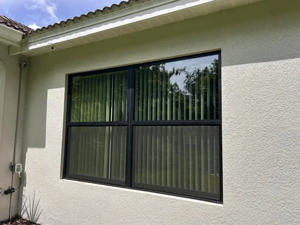 Black-framed rectangular window on a light stucco wall