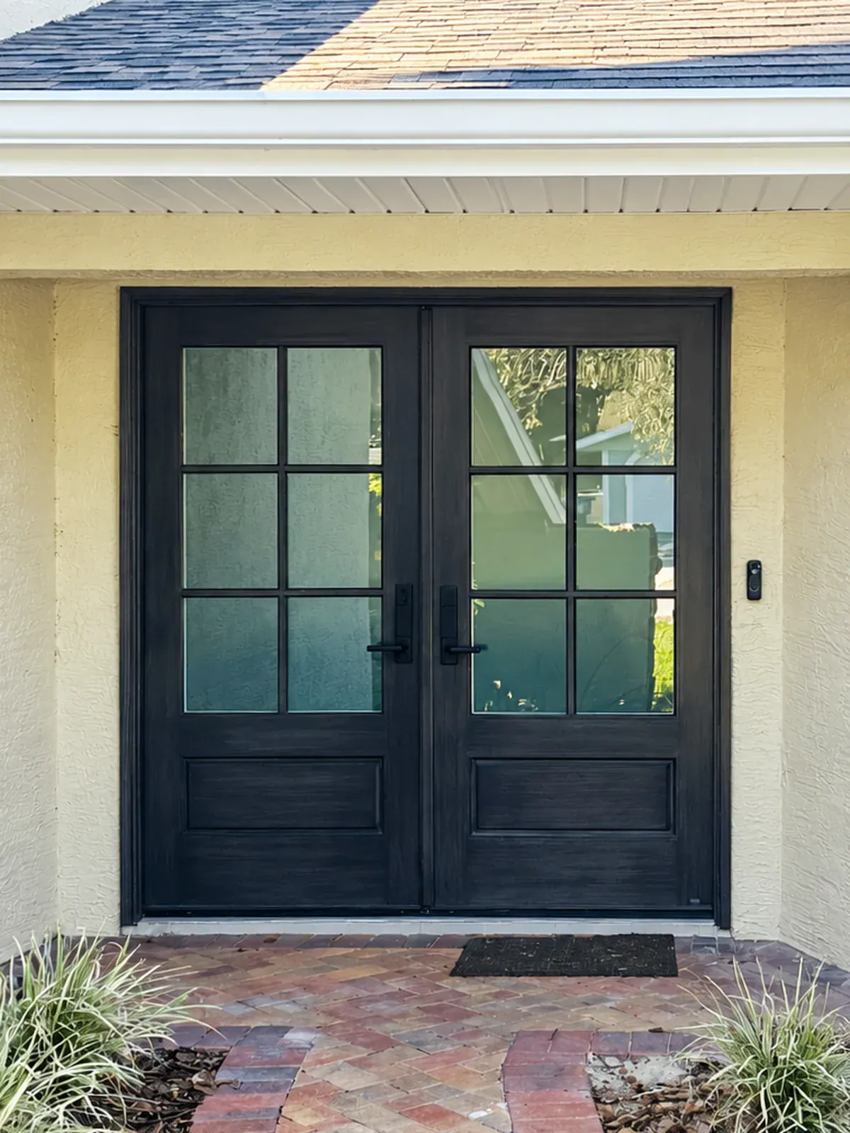 New dark impact double entry doors with divided-light glass after replacement