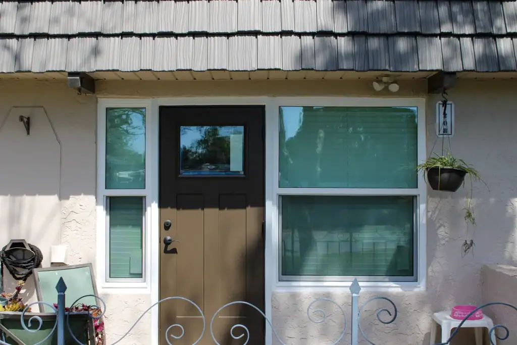 Entry door with a glass sidelight beside a white-framed window