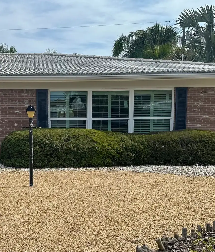 Front window group with shutters on a single-story brick home