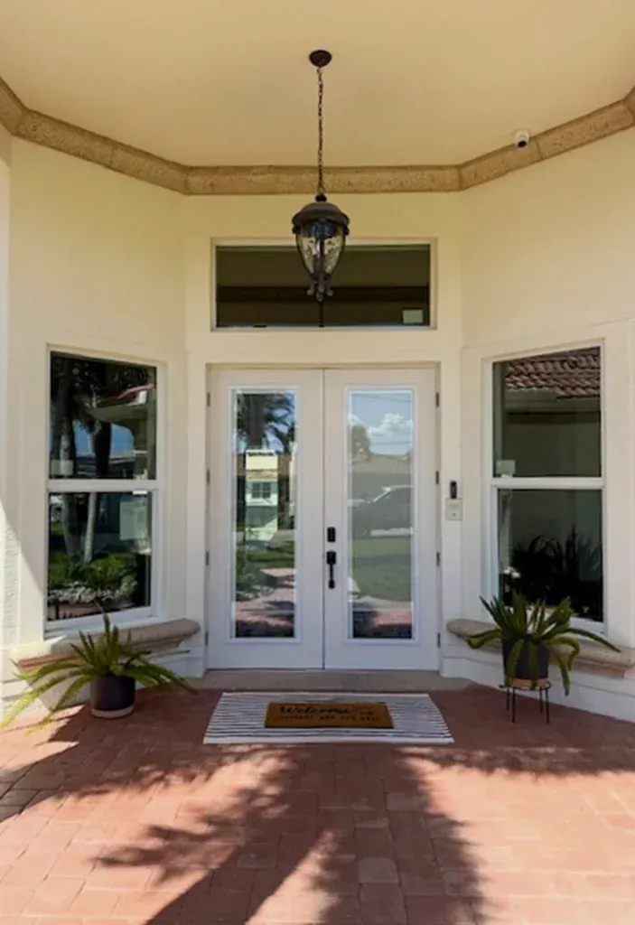 White glass entry doors with sidelights and a rectangular transom