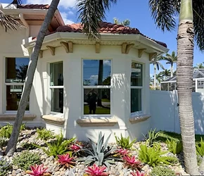 Impact bay window on a Florida home with palm landscaping installed by Storm Pro