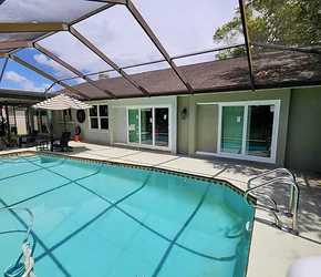 Impact sliding glass doors opening to a screened pool enclosure installed by Storm Pro
