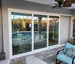 Impact sliding glass doors to a covered outdoor room installed by Storm Pro