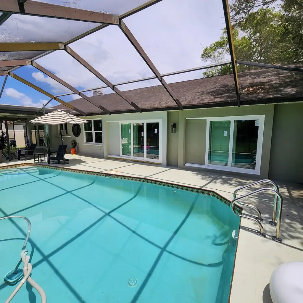 White sliding glass doors surrounding a screened swimming pool