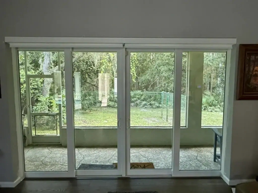 Interior view of white sliding glass doors facing a screened lanai