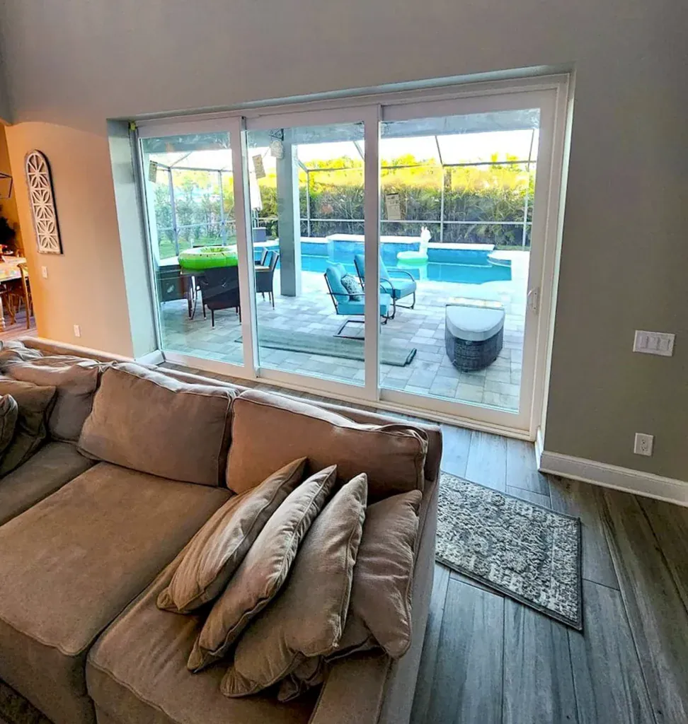 Living room sliding glass doors overlooking a pool and patio