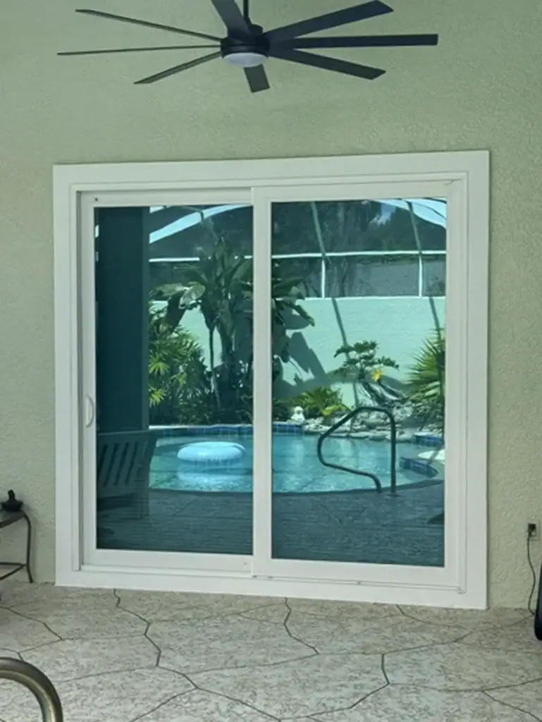 Two-panel sliding glass doors beneath a covered patio ceiling fan
