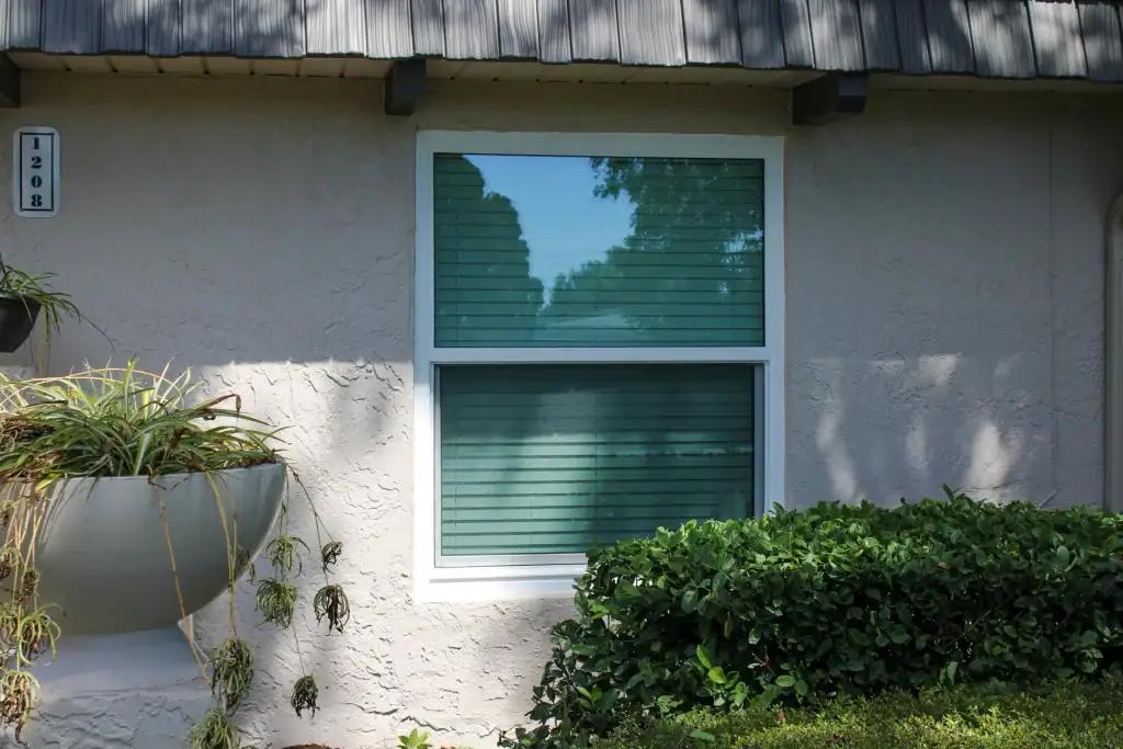 White single-hung window on a stucco home exterior