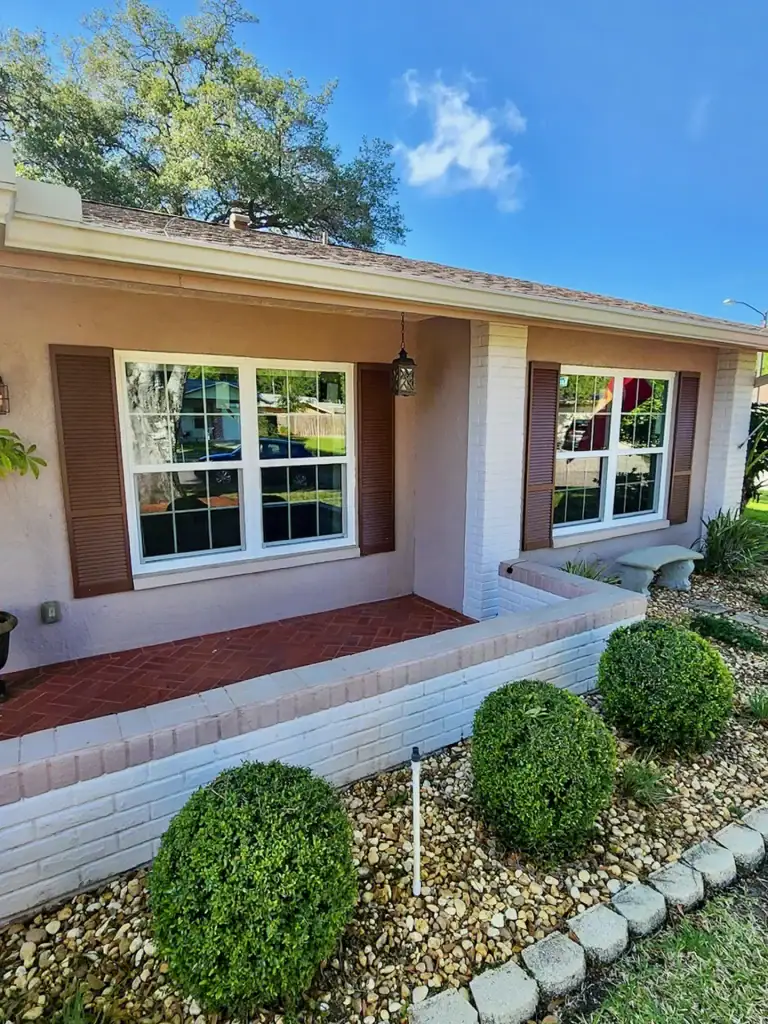 White divided-light windows along a landscaped front porch